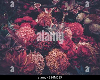 Image de style vintage mettant en vedette une profusion de fleurs artificielles dans des teintes riches et sombres, rappelant une célébration du nouvel an chinois. Banque D'Images