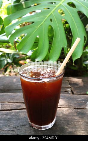 Verre de café noir glacé glacé isolé sur la table en bois de jardin Banque D'Images