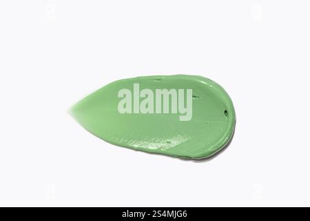 Une image en gros plan d'un échantillon de masque facial à spiruline vert éclatant et kaolin, conçu pour la désintoxication et le traitement de l'acné, isolé sur un fond blanc. T Banque D'Images