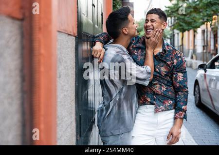 Un joyeux couple gay latin partage un moment tendre dans une rue animée de Madrid. Leur bonheur et leur connexion sont magnifiquement capturés dans cette ville Banque D'Images