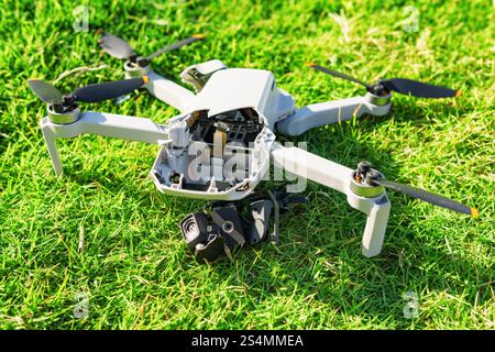 Accident avec un drone. Quadcopter endommagé sur herbe verte Banque D'Images