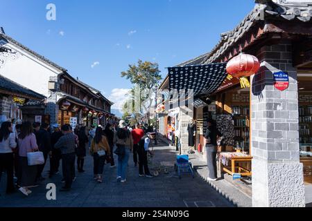 Vieille ville de Dali, Chine - 19 novembre 2024 : Une journée ensoleillée dans la vieille ville de Dali. La foule se promène dans les rues étroites bordées de boutiques traditionnelles et de buil Banque D'Images