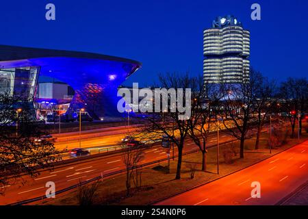 Moderne Architektur BEI Nacht. Die BMW-Welt und der BMW-Turm am Abend. Ausstellungsstätte und Hauptverwaltung des Fahrzeugherstellers BMW in München. München Bayern Deutschland *** architecture moderne la nuit BMW Welt et la tour BMW la nuit Centre d'exposition et siège du constructeur automobile BMW à Munich Munich Bavière Allemagne Copyright : xRolfxPossx Banque D'Images