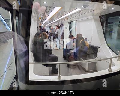 27-12-2024 Aéroport international de Munich, Allemagne. Les personnes utilisant le train-navette du terminal souterrain. Banque D'Images