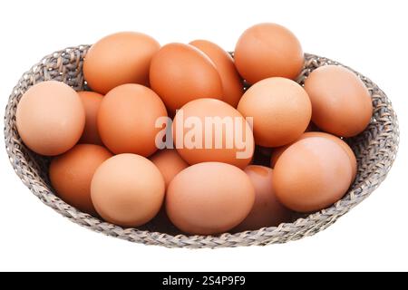 Beaucoup d'œufs de poulet frais dans panier en osier isolé sur fond blanc Banque D'Images