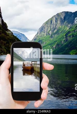 Concept de voyages touristiques - taking photo de fjord en Norvège le gadget mobile Banque D'Images