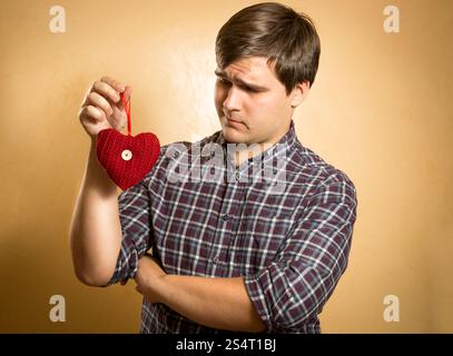 Portrait de bel homme à la louche sur le cœur rouge décoratif Banque D'Images