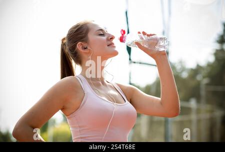 Closeup portrait of young woman having slim casser à l'exécution et de l'eau potable Banque D'Images