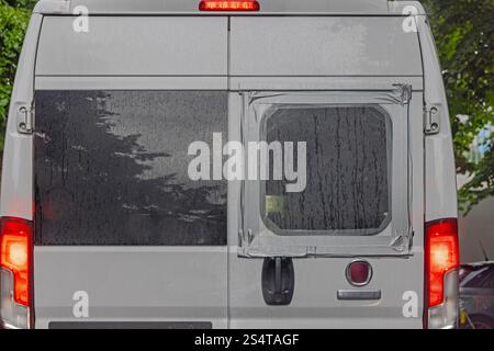 Lunette arrière brisée recouverte de plastique et de ruban adhésif chez Campervan Banque D'Images