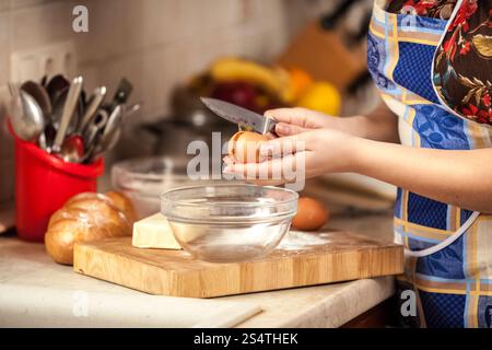 Photo gros plan de la femme au foyer à l'aide d'un couteau d'oeufs de fissuration Banque D'Images