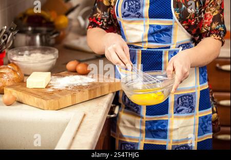 Photo gros plan de la femme en fouettant les oeufs dans un bol en verre Banque D'Images