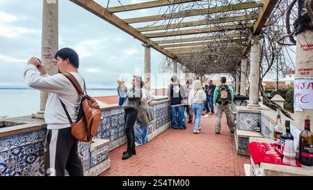 Les touristes apprécient la vue panoramique imprenable sur les toits de Lisbonne et le Tage depuis le point de vue populaire de Miradouro de Santa Luzia. Banque D'Images