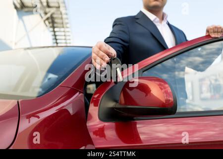 Photo gros plan de beau vendeur de voiture touches donnant Banque D'Images