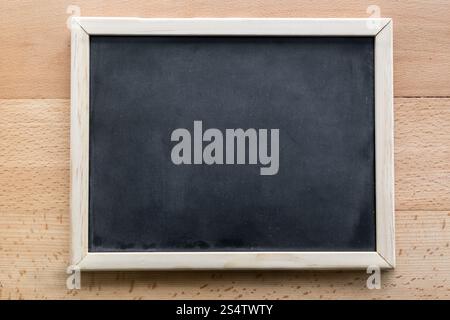 Coup horizontal du tableau vide posé sur un bureau en bois Banque D'Images