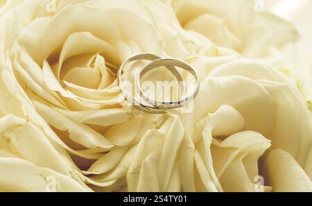 Arrière-plan pour ton mariage avec joints toriques couchée sur des roses blanches Banque D'Images