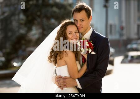 Portrait de couple heureux juste marié serrant dans la rue Banque D'Images