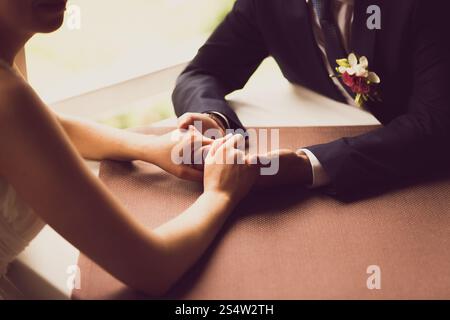 Gros plan sur la photo de mariée et mariée se tenant la main au restaurant Banque D'Images