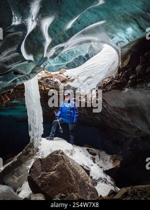 Le voyageur est dans une grotte de montagne faite de glace. Des aventures incroyables dans les montagnes. Glacier Bogdanovich Banque D'Images