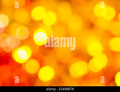 Résumé arrière-plan flou - jaune et rouge scintillant de lumières de Noël des guirlandes électriques sur l'arbre de Noël Banque D'Images