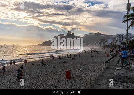 Les gens se rassemblent sur la plage de Leblon au coucher du soleil, Rio de Janeiro, Brésil. Banque D'Images