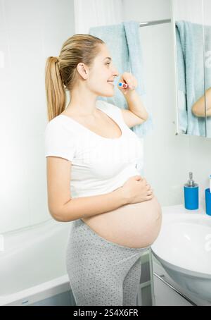 Magnifique Portrait de femme enceinte se brosser les dents à bains Banque D'Images