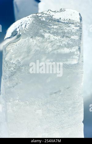 Haut transparent fusion morceau de glace éclairée par le soleil du printemps libre. Banque D'Images
