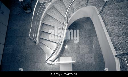 L'image monochrome aux couleurs de l'escalier de pierres incurvées au bâtiment moderne Banque D'Images