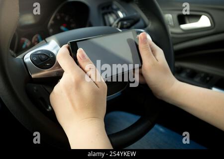 Gros plan du conducteur tapant un message pendant la conduite Banque D'Images