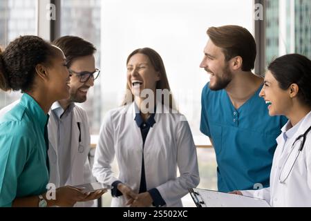Les membres heureux du personnel de la clinique en riant se sont rassemblés dans le bureau de la clinique Banque D'Images