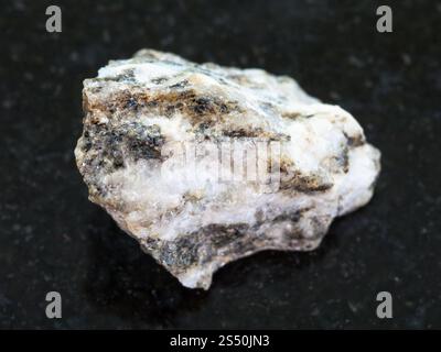 La prise de vue macro des eaux minérales naturelles rock specimen - pierre de gneiss granitique sur fond sombre Banque D'Images