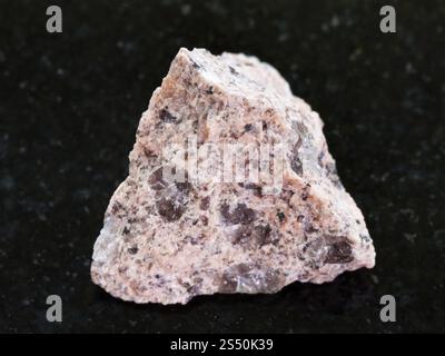 La prise de vue macro des eaux minérales naturelles rock specimen - pierre de granit brut sur fond de granit sombre Banque D'Images