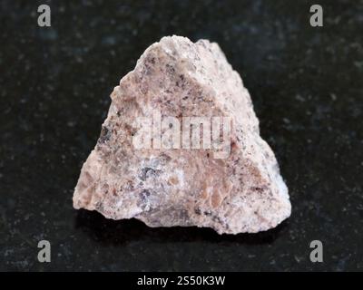 La prise de vue macro des eaux minérales naturelles rock specimen - pierre de granit rugueux sur fond de granit sombre Banque D'Images