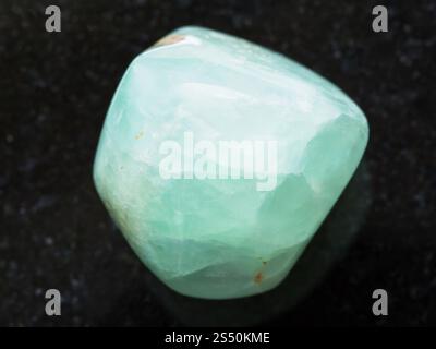 La prise de vue macro des eaux minérales naturelles rock specimen - tumbled préhnite gemstone sur fond de granit foncé à partir de la République du Mali Banque D'Images