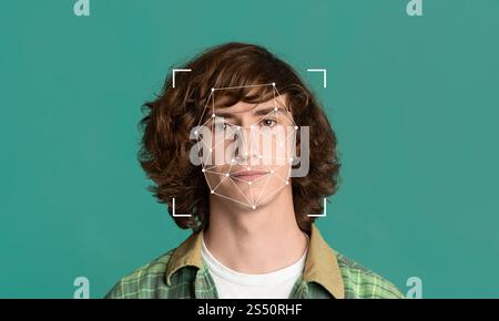 Un jeune homme aux cheveux bouclés se tient sur un fond vert solide Banque D'Images