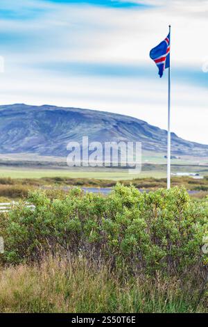 Voyager en Islande - drapeau islandais près de Kerid Lake en septembre soir Banque D'Images