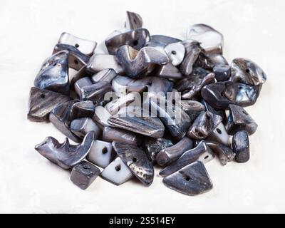 Tas de pierres naturelles perles de nacre sur fond de béton gris Banque D'Images