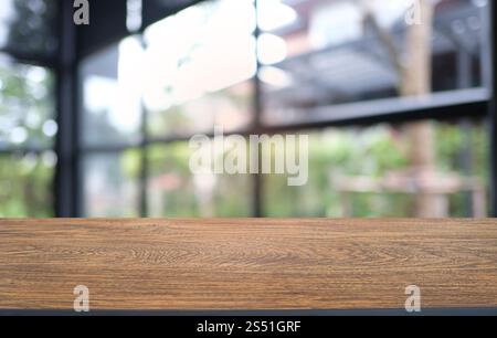 Table en bois sombre vide devant le fond abstrait flou bokeh du restaurant. peut être utilisé pour l'affichage ou le montage de vos produits. Maquette pour Banque D'Images
