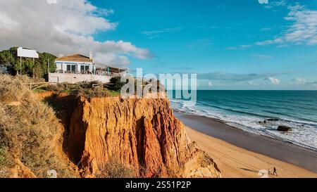 Magnifique coucher de soleil sur la côte à Portimão, Portugal, avec le soleil qui brille sur les falaises supérieures et la plage vue de la mer Banque D'Images