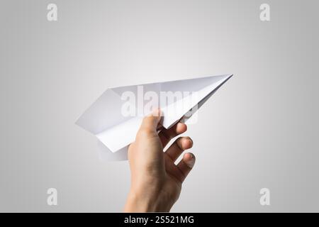 Avion de Papier Dart main femme isolé sur fond blanc. Banque D'Images