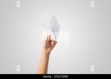 Avion de Papier Dart main femme isolé sur fond blanc. Banque D'Images