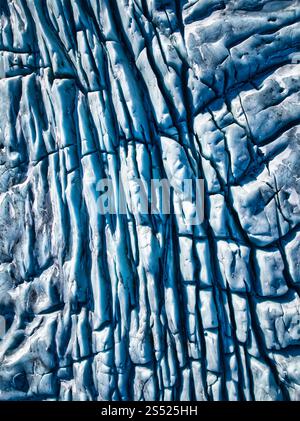 Vue aérienne rapprochée de crevasses et de lignes complexes sur un glacier en Islande, mettant en valeur les motifs et les textures étonnants de sa surface glacée Banque D'Images
