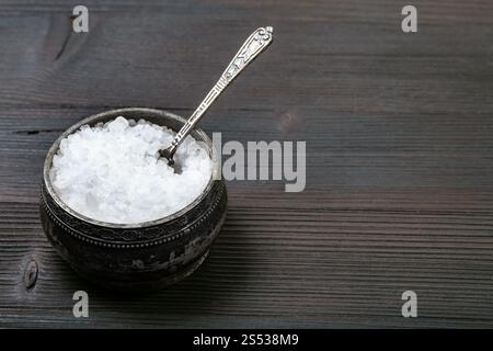 Sel d'argent vintage avec cave avec une cuillère de sel de mer à gros grains sur conseil en bois brun foncé Banque D'Images
