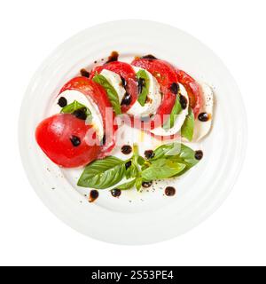 cuisine italienne insalata caprese (salade caprese) - vue de dessus de tranches de fromage mozzarella et tomate avec des feuilles de basilic assaisonnées d'huile d'olive et Banque D'Images