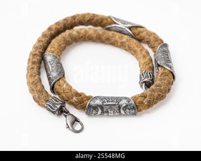 Collier vintage en spirale à partir de la corde de coton avec des anciennes pièces d'argent sur fond de papier blanc Banque D'Images
