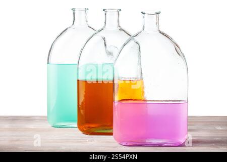 flacons en verre avec des solutions d'aquarelle de couleur sur panneau de bois avec fond de découpe. flacons en verre avec solutions d'aquarelle isolés Banque D'Images