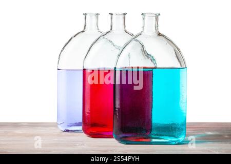 flacons en verre avec des solutions d'encre de couleur sur panneau de bois avec fond de découpe. flacons avec des solutions d'encre de couleur sur planche de bois Banque D'Images