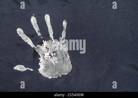 détail de l'ornement avec des empreintes de main peintes à la main sur écharpe de soie noire artisanale isolé sur fond blanc. ornement avec des empreintes de main peintes à la main sur Banque D'Images