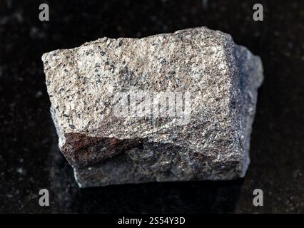 Gros plan de l'échantillon de minéral naturel de la collection géologique - roche Pyrrhotite (Pyrotite) non polie sur fond de granit noir de Kola Banque D'Images