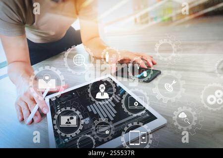 E-learning avec engrenages connectés diagramme connecté tableau de bord virtuel.homme d'affaires travaillant avec une tablette numérique et un téléphone intelligent avec numérique Banque D'Images