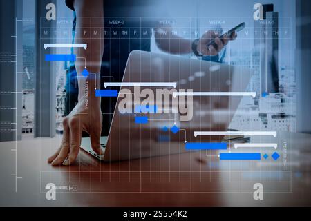 Gestionnaire de projet et de travail avec les tâches de mise à jour des progrès et la planification des étapes de planification de Gantt Designer.Schéma de travail à la main et un téléphone intelligent Banque D'Images